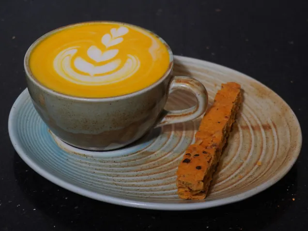 Yellow pepper veloute served cappuccino style with a cheese straw