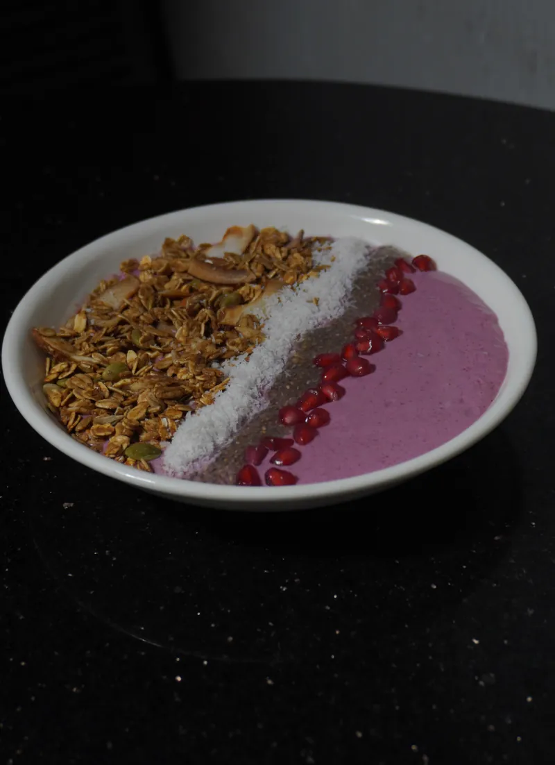 Mixed berry smoothie bowl with granola, coconut and pomegranate