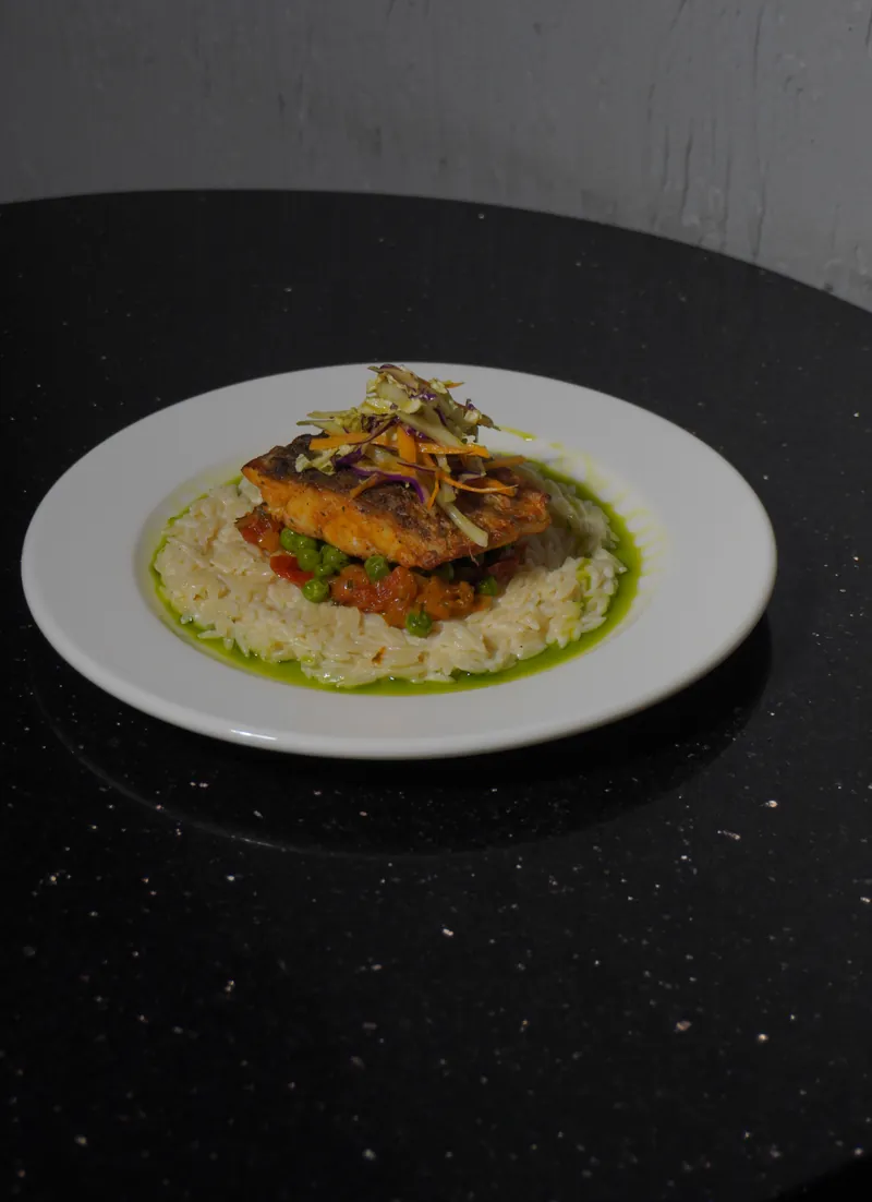 Sea bass a la Bilbaina on a bed of herb salsa verde